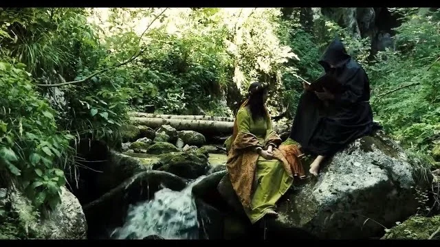 Documentario Fiöi dal Nos: figuranti in costume storico presso un torrente nel bosco delle Valli del Noce